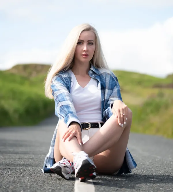 Woman sitting outdoors beside a country road
