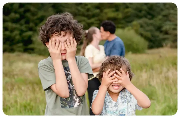 Children playing outdoors with their parents behind them